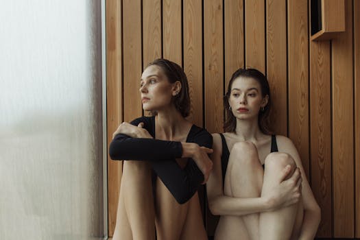 Two women in a sauna, relaxing and reflecting in a modern wellness environment.