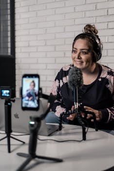 Woman recording video podcast with microphone and camera setup in modern studio.