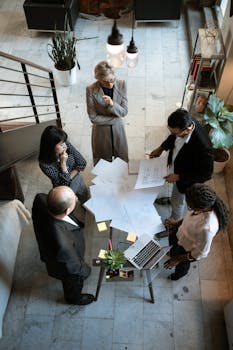 A team of professionals engage in a business meeting in a sleek, modern office setting.