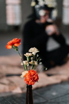 Creative composition featuring vibrant flowers and blurred human figure.
