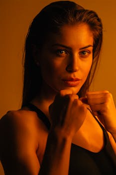 Portrait of a confident woman in a studio with warm lighting showcasing strength and determination.