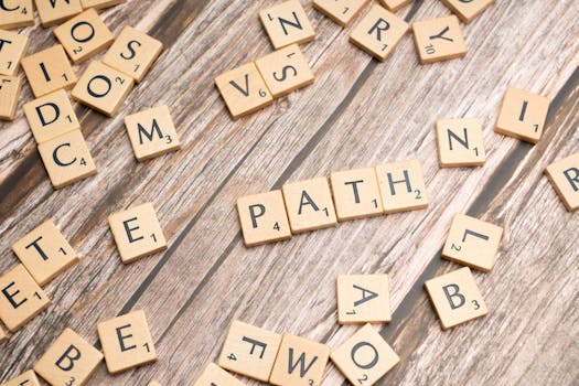 Scrabble tiles spelling 'Path' on a rustic wooden background, symbolizing direction and choice.